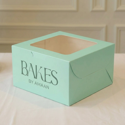Light green cake box with 'Bakes by Amaan' branding on a neutral background